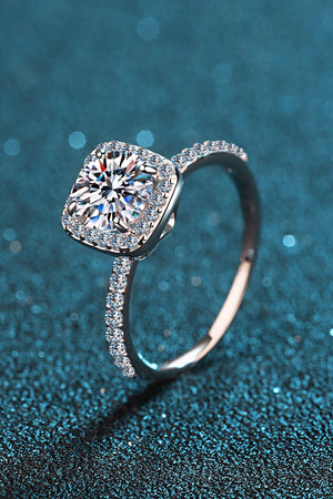 Cushion halo engagement ring in silver with pave band and center stone.
