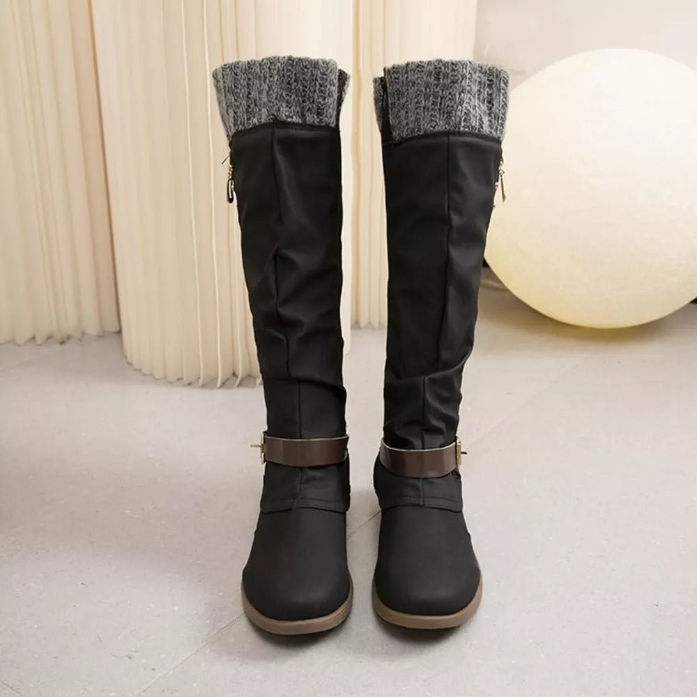 Black suede knee-high slouch boots with grey knit detail and brown buckle strap.