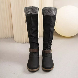 Black suede knee-high slouch boots with grey knit detail and brown buckle strap.