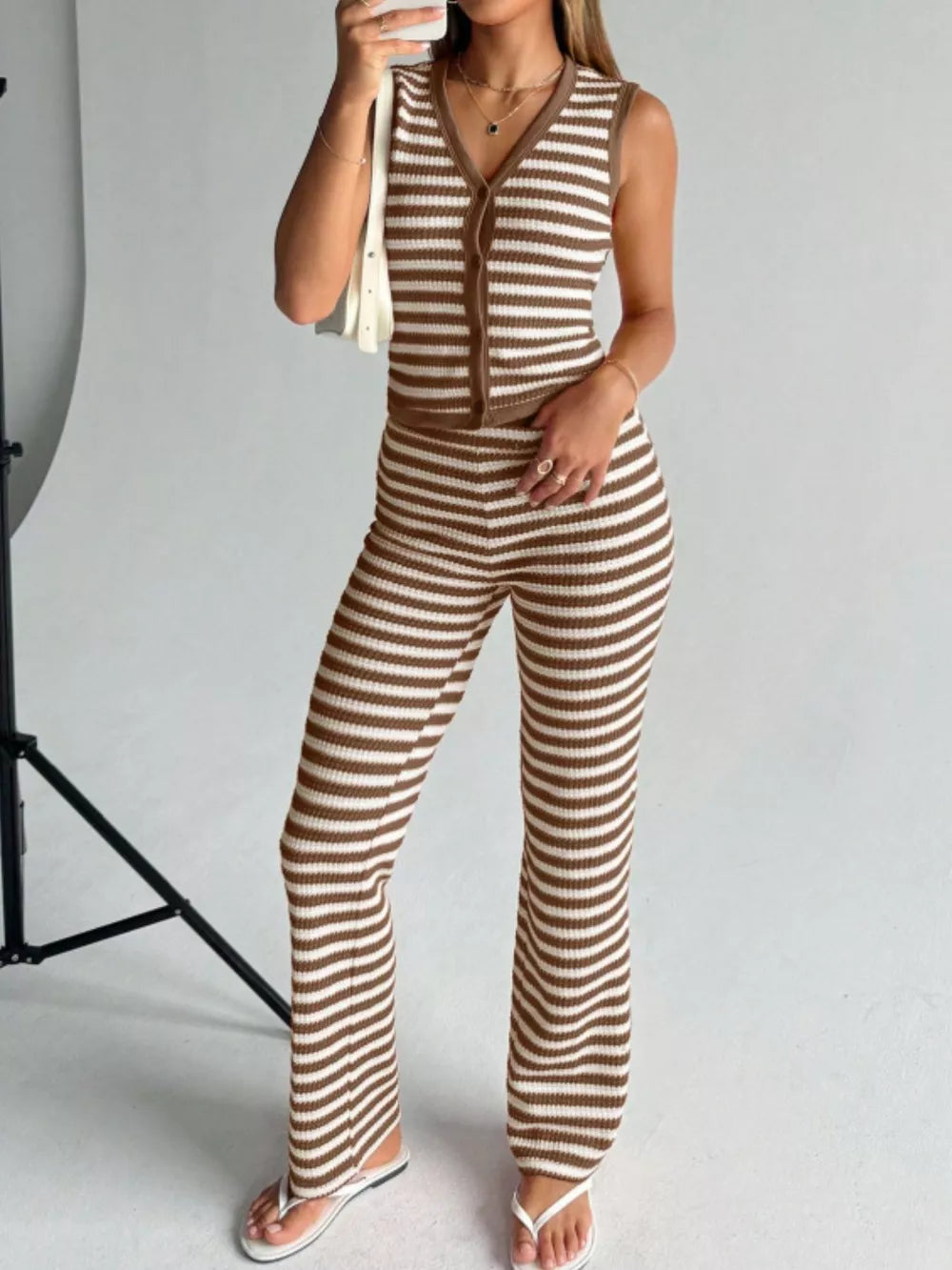 Brown and white striped knit V-neck buttoned sleeveless top and flared pants set.