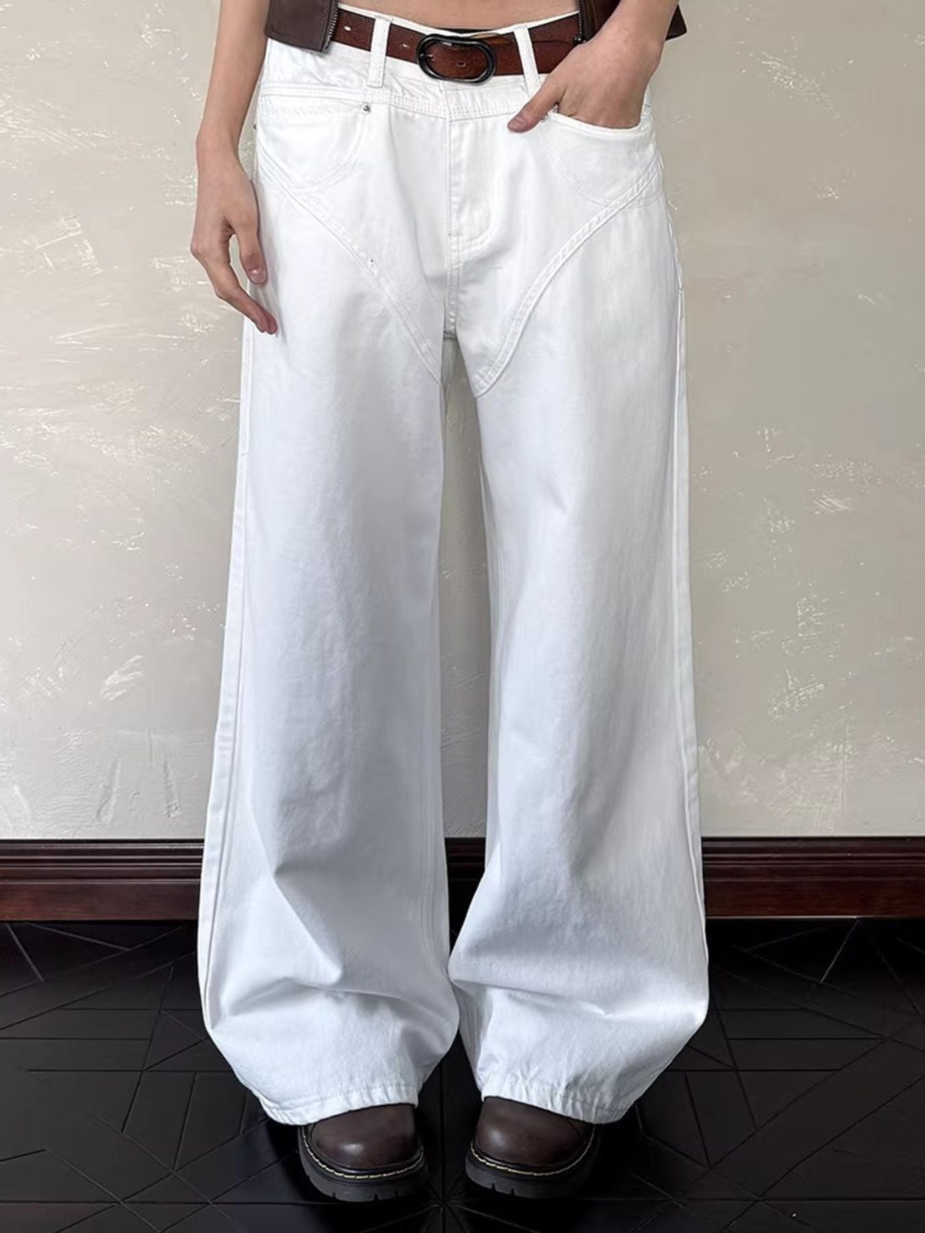 Belted wide leg white cotton jeans with a dark brown belt.