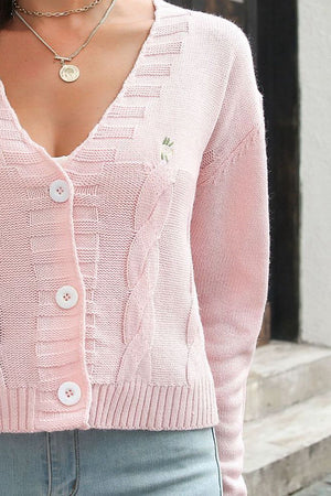 Pink cable knit button-up cardigan with embroidered detail and white buttons