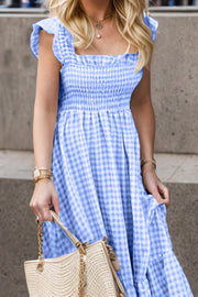 Blue gingham smocked maxi dress with flutter sleeves and square neckline.