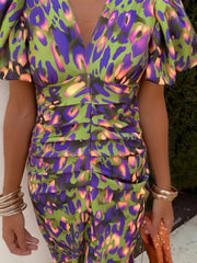 Vibrant abstract print midi dress with V-neck, puff sleeves, and ruched skirt.