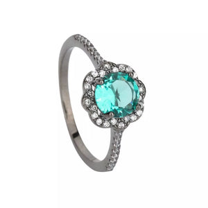 Elegant sterling silver ring with a large teal zircon surrounded by small white crystals.