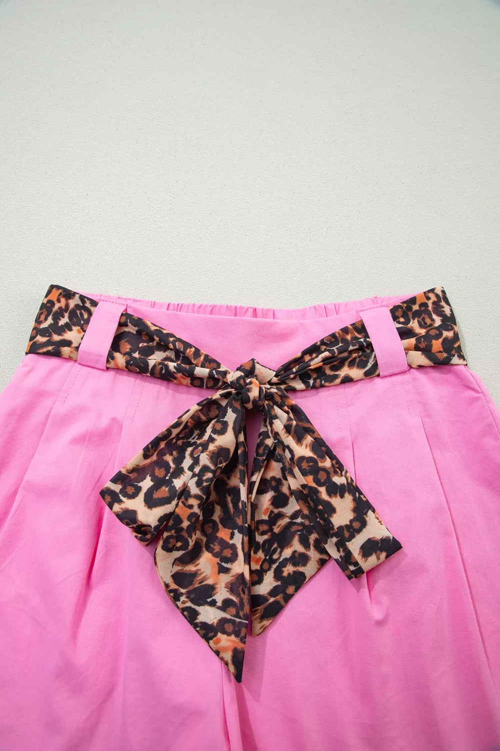 Pink chino shorts with high waist and leopard print belted bow detail.