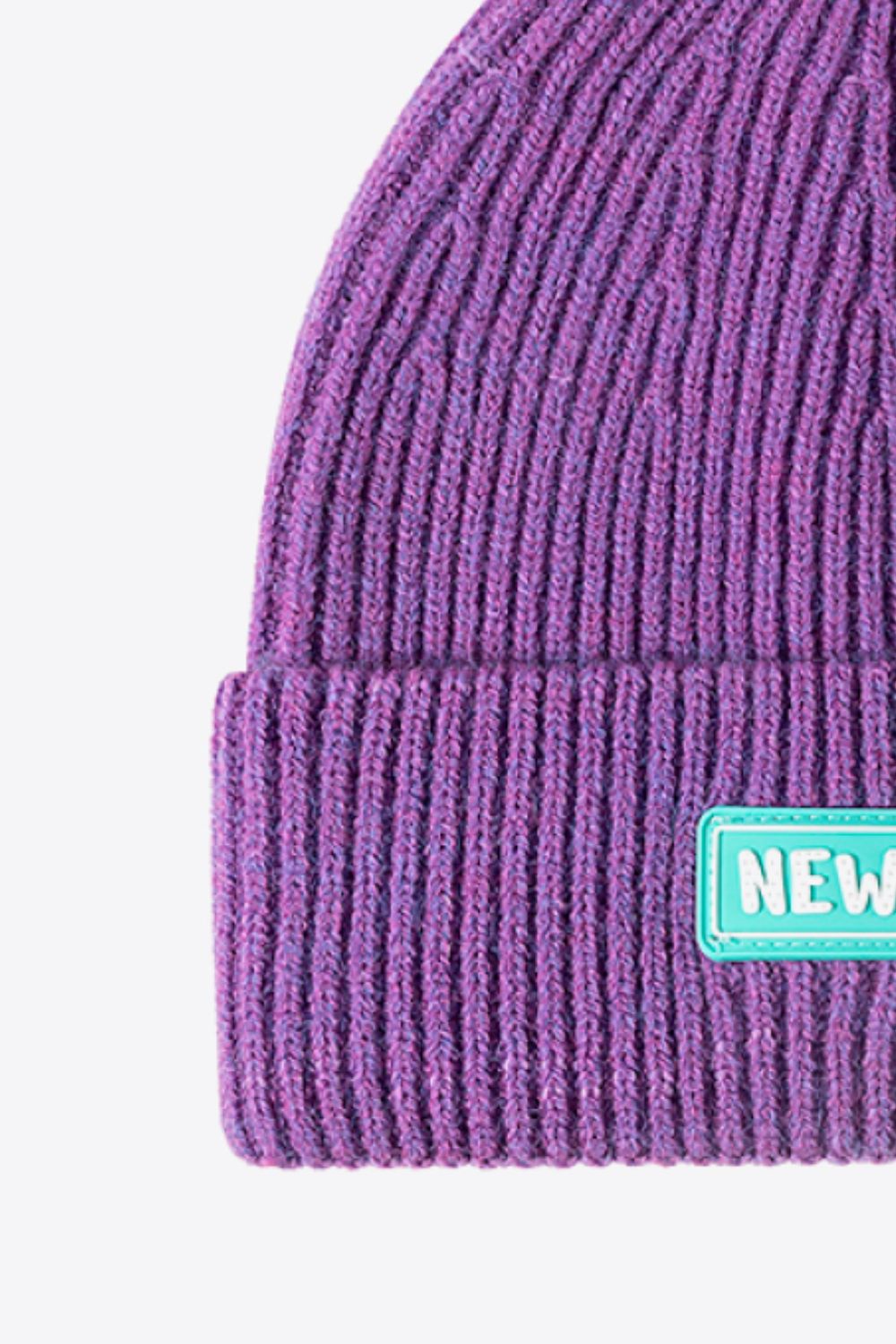 Purple ribbed acrylic beanie with a New York patch detail.