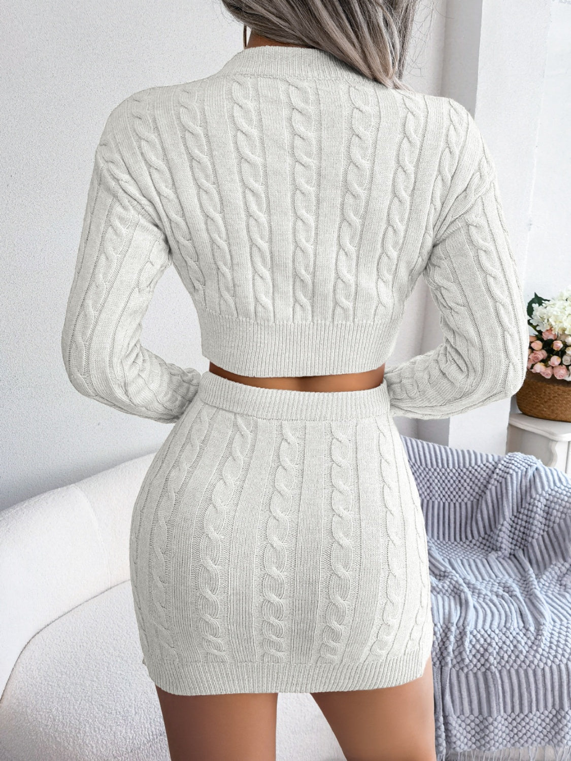 White cable knit crop co-ord set with a mini skirt and long sleeve sweater.