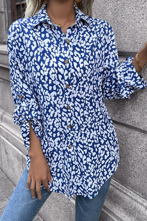 Sky blue oversized shirt with abstract spot print, buttoned front, and rolled sleeves.