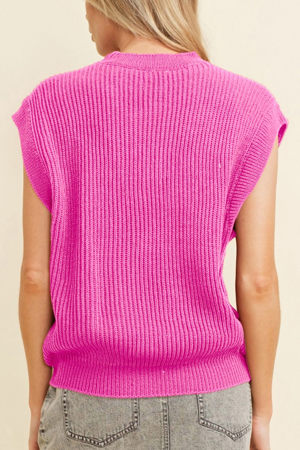Fuchsia pink ribbed knit vest with a mock neck and sleeveless design.