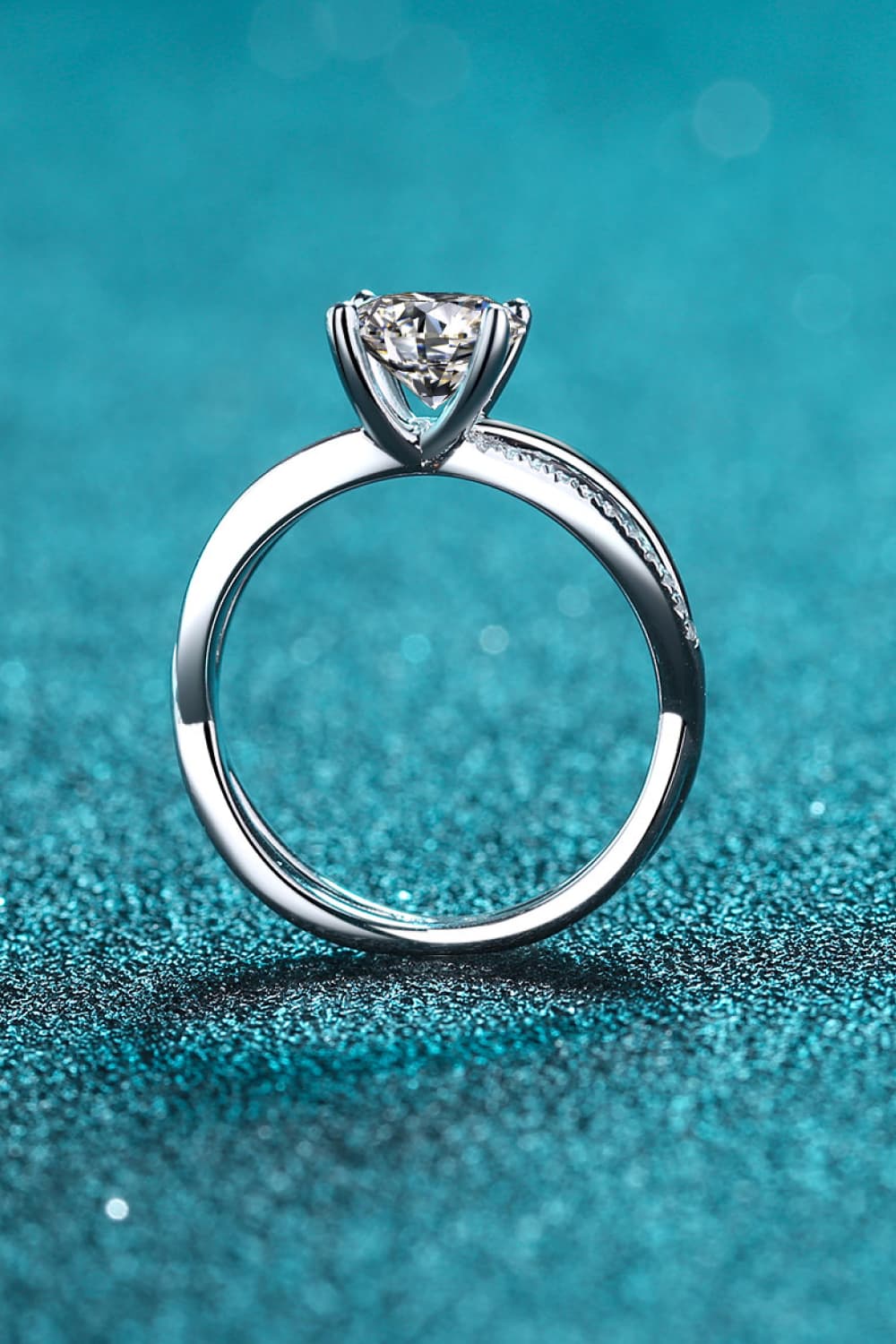 Silver crossover moissanite solitaire ring with pavé detail on band