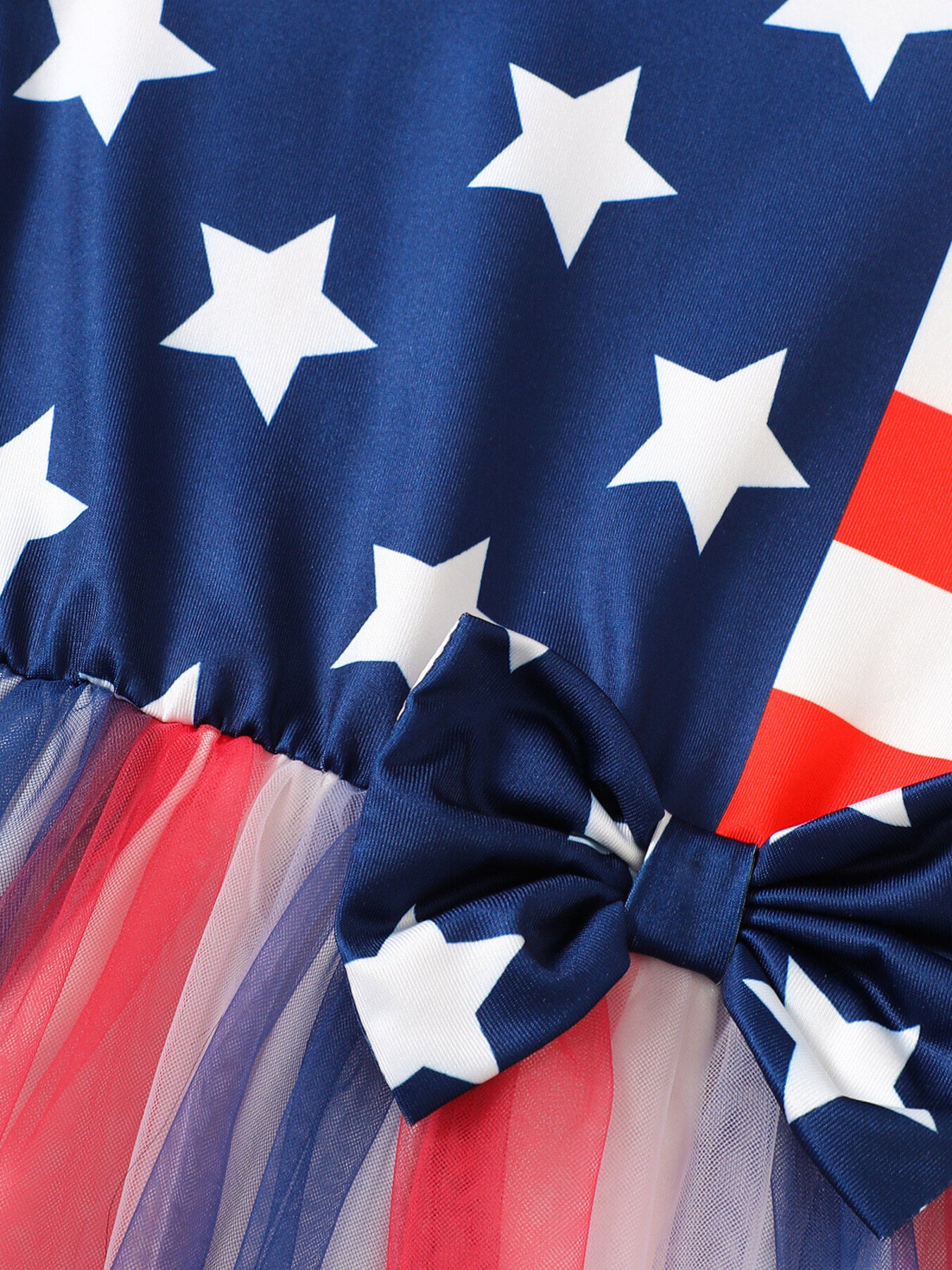 Baby dress with stars and stripes pattern, blue bow, and tulle skirt.