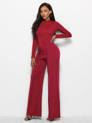 Red high-waisted palazzo jumpsuit with slit front and long sleeves.