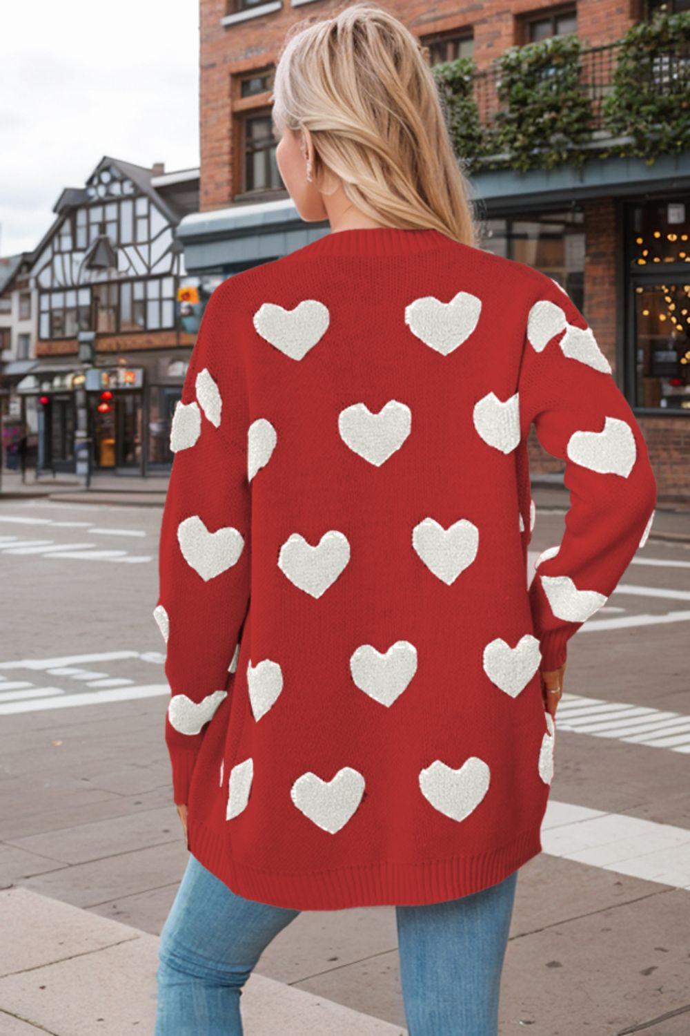 Scarlet knit cardigan with white heart appliqué pattern and long sleeves.