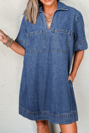 Medium blue denim utility mini dress with collar, short sleeves, two chest pockets and side pockets.