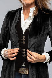 Black velvet duster coat with ornate buttons and dramatic split back detail.