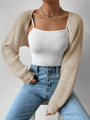 Khaki knit bolero shrug with long ribbed sleeves worn over a white camisole.