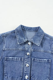 Medium wash denim romper with button-down front and chest pockets.