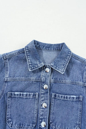 Medium wash denim romper with button-down front and chest pockets.