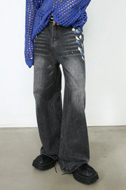 Dark wash flare jeans with artistic paint splatters and abstract blue, white, and gray accents.