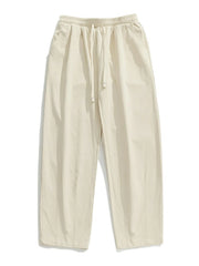 Ivory wide-leg pleated drawstring trousers with a relaxed fit and side pockets.