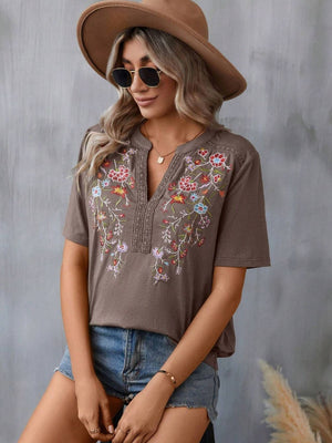 Taupe V-neck tee with colorful floral embroidery and crochet trim detail.