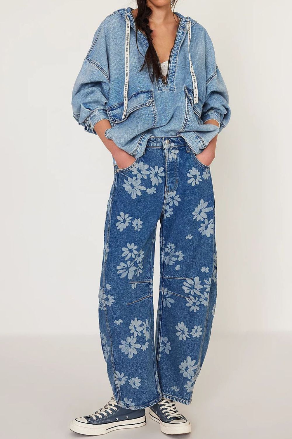 Floral print balloon jeans in medium wash denim with a relaxed fit and all-over blossom pattern.