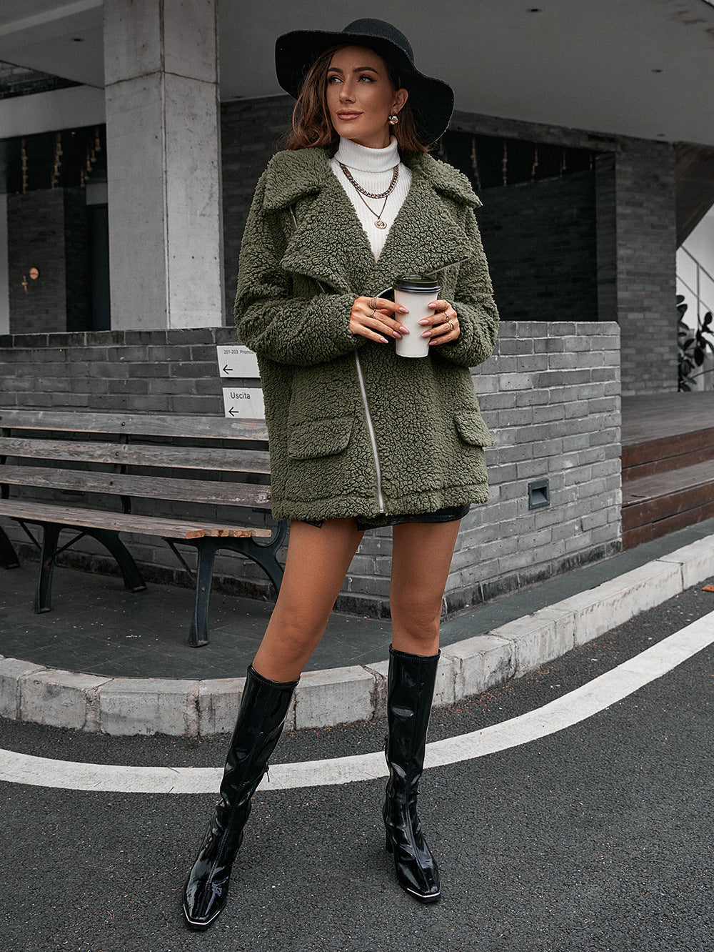 Green teddy moto jacket with asymmetrical zip and collared neckline.