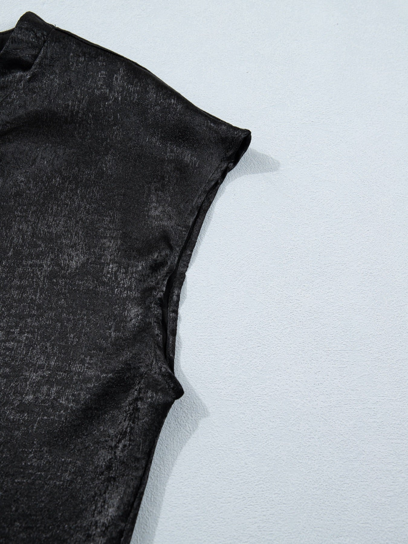 Black metallic tee with cap sleeves and a textured finish.