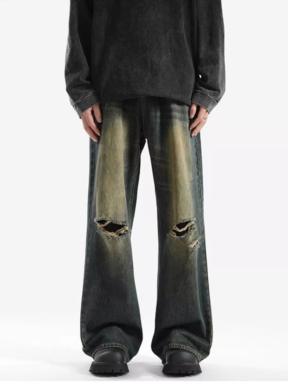 Men's distressed wide-leg jeans with ripped knees and faded wash.
