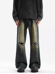 Men's distressed wide-leg jeans with ripped knees and faded wash.