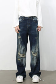 Dark wash oversized wide leg jeans with distressed details and rips.