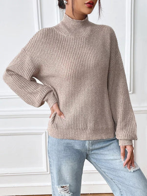 Relaxed fit ribbed knit turtleneck sweater in beige acrylic with balloon sleeves.