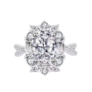 Sterling silver ring with oval moissanite center stone and halo of round and baguette stones.