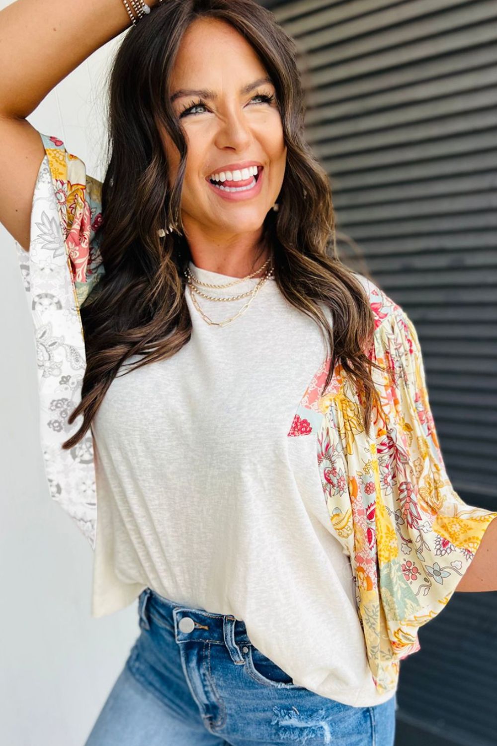 Beige t-shirt with patchwork floral print sleeves and a crew neck.