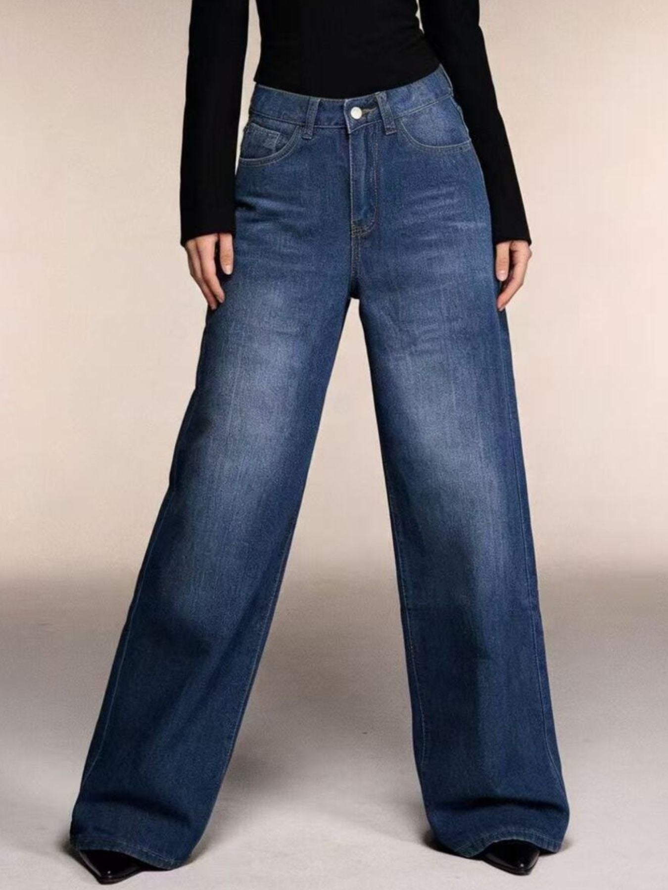 Cutout high-waisted wide-leg jeans in blue denim with button closure and pockets.