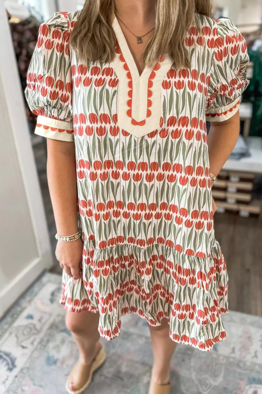 Cotton mini dress with red tulip print, puff sleeves, and ruffled hem.