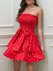 Red smocked strapless mini dress with white hearts, tiered skirt, and bow belt.
