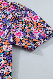 Floral print polyester shirt with V-neck and elastic cuff puff sleeves.