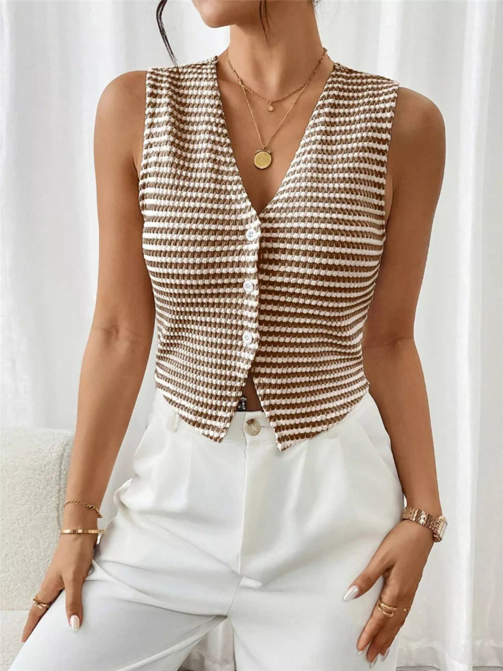 Chic striped knit v-neck tank top with button front, styled with white pants.