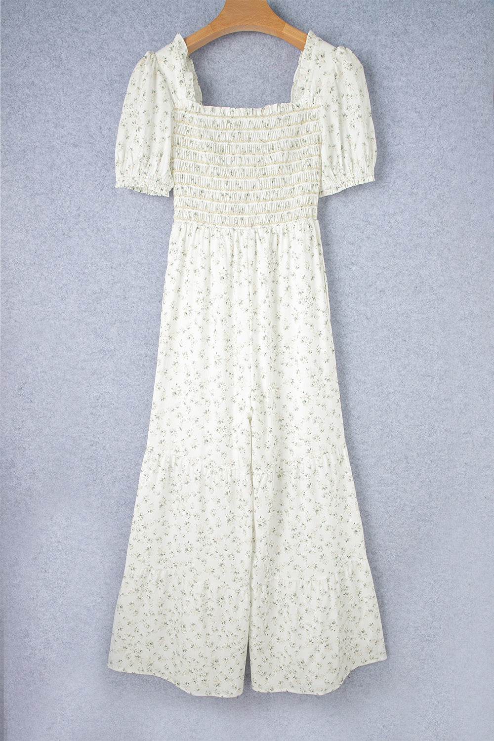 White floral smocked bodice wide-leg jumpsuit with puff sleeves.