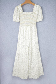White floral smocked bodice wide-leg jumpsuit with puff sleeves.