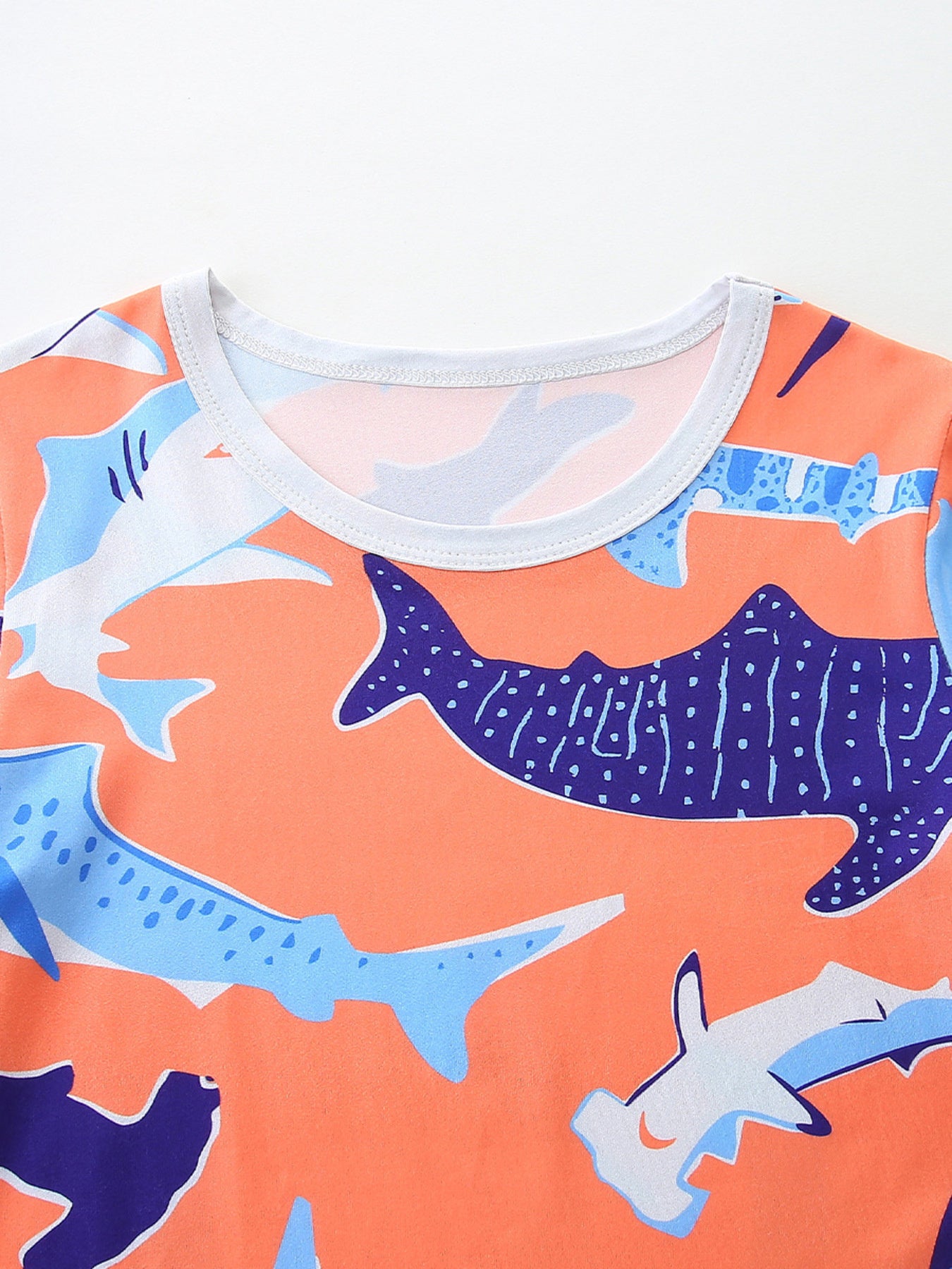 Toddler boys' orange t-shirt with a playful shark print and crew neck.