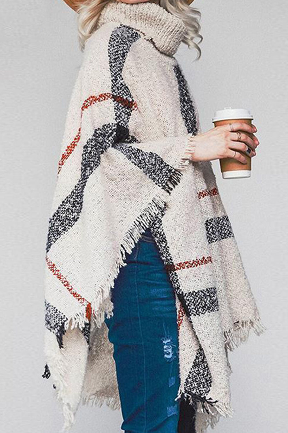 Beige plaid turtleneck cape with fringe details and a cozy acrylic knit.