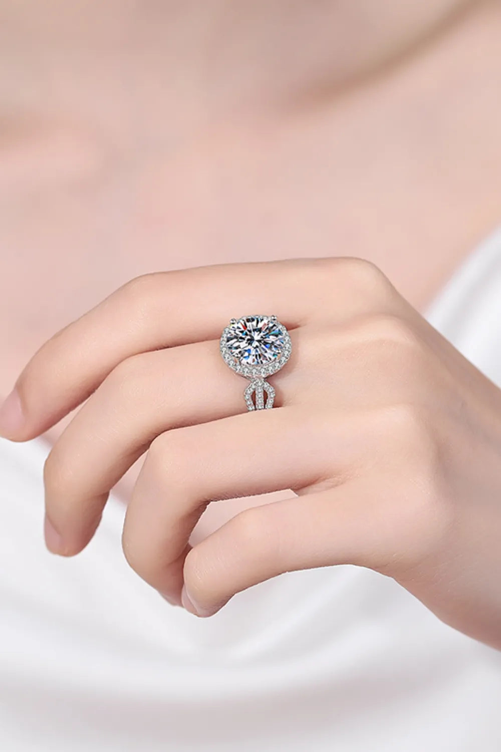 Sterling silver halo moissanite ring with a sculpted band and pavé accents.