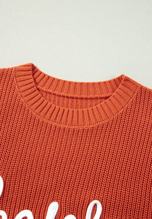 Orange knit sweater with white text detail and crew neck.