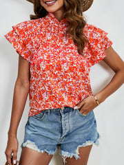 Orange floral blouse with ruffled neckline and flutter sleeves