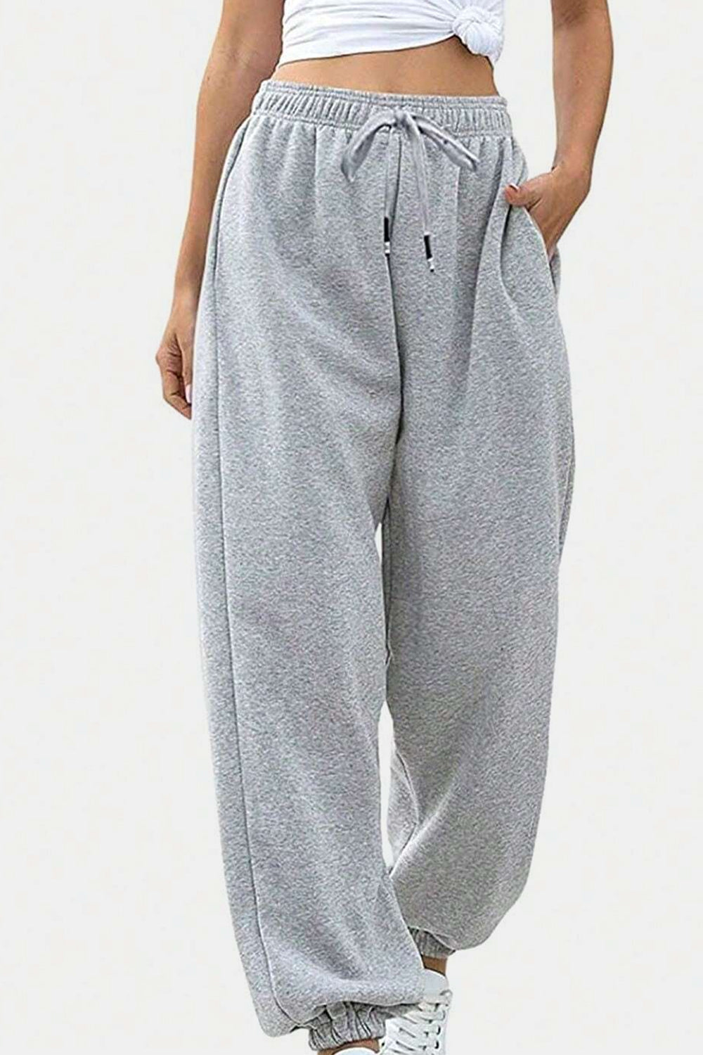 Relaxed-fit sweatpants in light gray with drawstring waist and cuffed ankles.