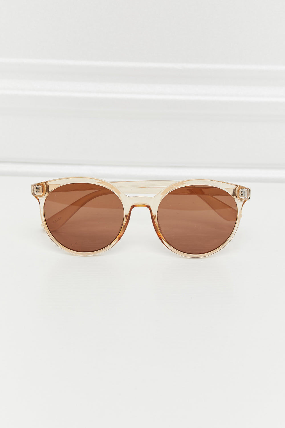 Tortoiseshell round frame sunglasses with tan translucent frames and brown lenses.