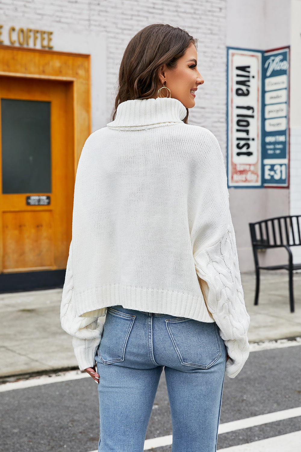 White cropped cable knit turtleneck sweater with a high neck and relaxed fit.